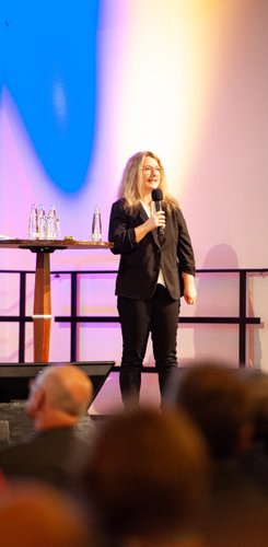 Geschäftsleiterin Mandy Guttzeit auf der Bühne während des 17. Dialogforums zur Stadt-Umland-Bahn